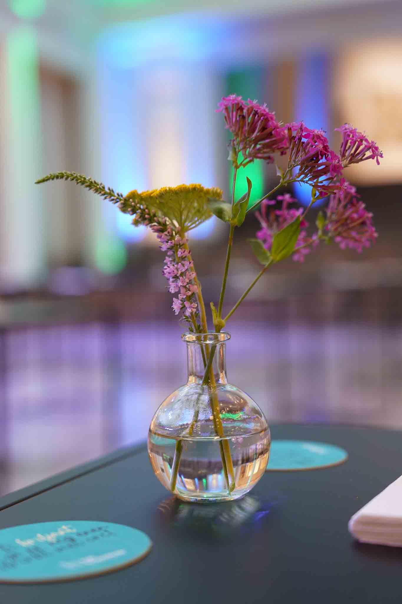 Kleine glazen vaas met bloemen als decoratie.